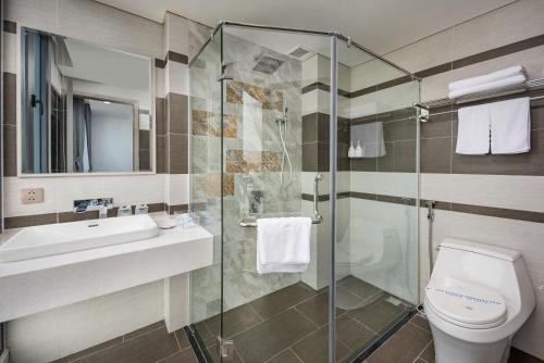 a bathroom with a shower and a toilet and a sink at Calix Hotel Da Nang in Da Nang