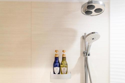 Chalet Villars في هاكوبا: زجاجتان من النبيذ على حامل في الحمام