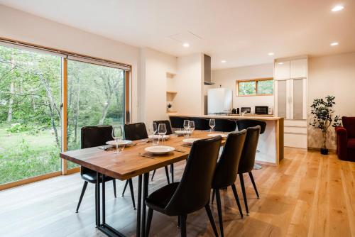 a dining room with a wooden table and chairs at Chalet Villars in Hakuba