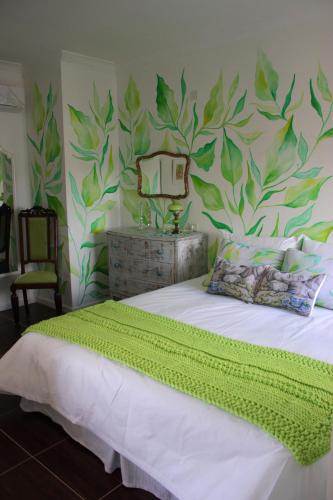 a bedroom with a bed with a green leafy wall at Allegra Dalila Casa Hotel-Arte in Tandil