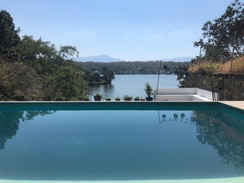 a swimming pool with a view of a lake at Experiencia Teques in Tequesquitengo