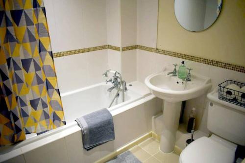 łazienka z umywalką, wanną i toaletą w obiekcie Comfortable Apartment in Sheffield with Parking w mieście Neepsend