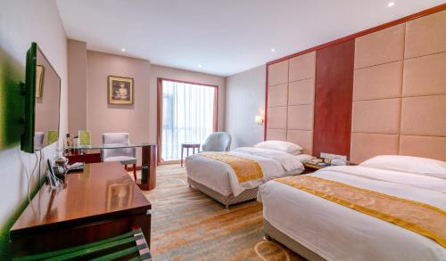 a hotel room with two beds and a desk at Yantai Meiya International ApartHotel (Previous Ramada Plaza) in Yantai