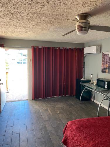 a living room with a red curtain and a table at Capri Beach Hotel in Corpus Christi