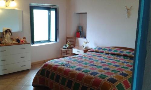 um quarto com uma cama, uma cómoda e uma janela em rurale em Nocera Terinese