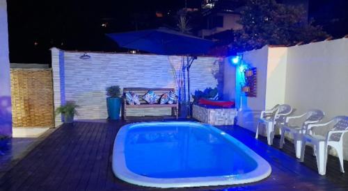 a swimming pool in a backyard at night at Recanto dos Pássaros in Ilhabela