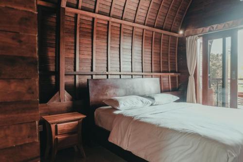 a bedroom with a bed and a window at Sekar Arum Riverside Resort in Canggu in Tanah Lot