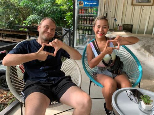a man and a woman sitting in chairs making peace signs at BeachBox@Koh Сhang in Ko Chang