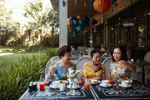 a group of three people sitting at a table at Salinda Resort Phu Quoc - Sparkling Wine Breakfast in Phu Quoc
