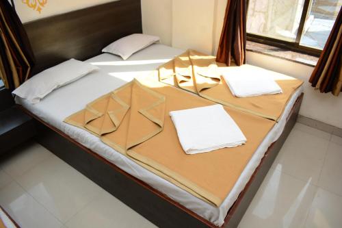 two beds in a room with white sheets at Hotel Sai Sampada NX in Shirdi