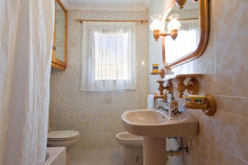 a bathroom with a sink and a toilet and a mirror at Villa Odisea in Calpe