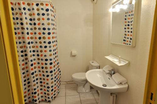 uma casa de banho com um WC, um lavatório e uma cortina de chuveiro em Residhotel Cannes Festival em Cannes