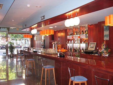 un bar avec tabourets bleus dans un restaurant dans l'établissement Hotel Doña Urraca, à Zamora