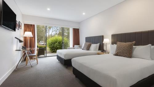 a hotel room with two beds and two lamps at Crowne Plaza Hunter Valley, an IHG Hotel in Lovedale