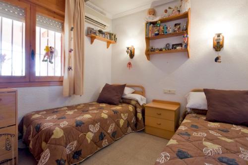 a bedroom with two beds and a window at Villa Odisea in Calpe