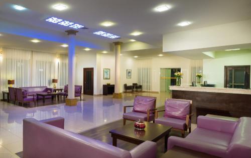 a lobby with purple chairs and tables in a hospital at City Hotel Duqm in Duqm