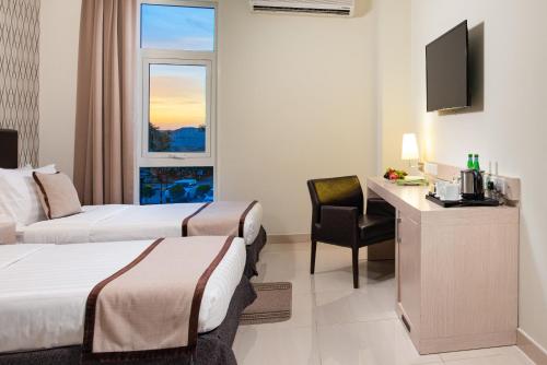a hotel room with two beds and a desk at City Hotel Duqm in Duqm