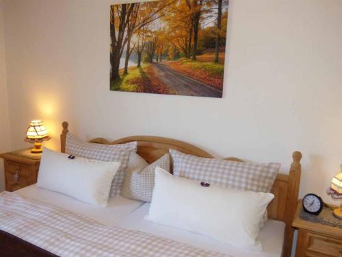 łóżko z białymi poduszkami i obrazem na ścianie w obiekcie Haus am Hochwald w mieście Mittenwald