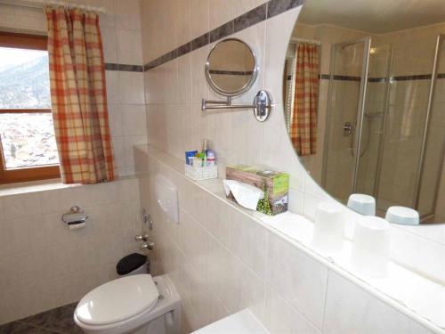 łazienka z toaletą, umywalką i lustrem w obiekcie Haus am Hochwald w mieście Mittenwald