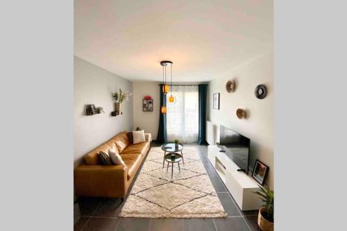 a living room with a couch and a table at Le Continental Beau T2 plein centre + parking in Annecy