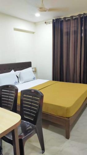 1 dormitorio con 1 cama, 1 silla y 1 mesa en Bhumi Residency, en Mangalore