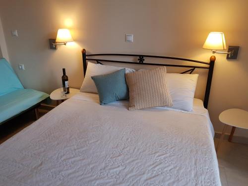 a bedroom with a bed with two lamps and a chair at Nefeli Wind Club in Vasiliki