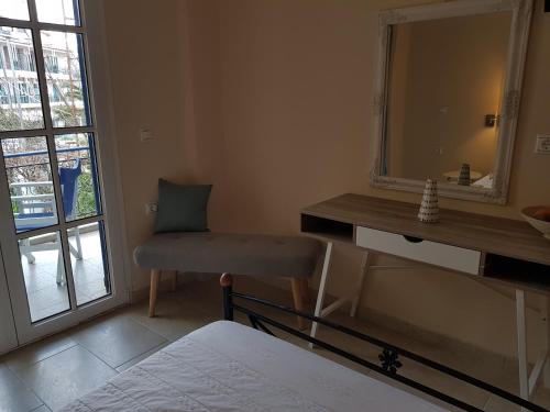 a bedroom with a mirror and a chair and a bed at Nefeli Wind Club in Vasiliki