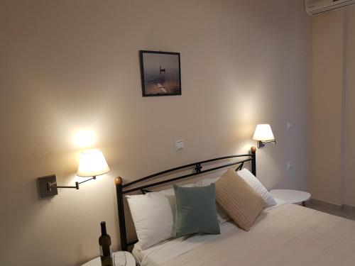 a bedroom with a bed with two lamps on it at Nefeli Wind Club in Vasiliki