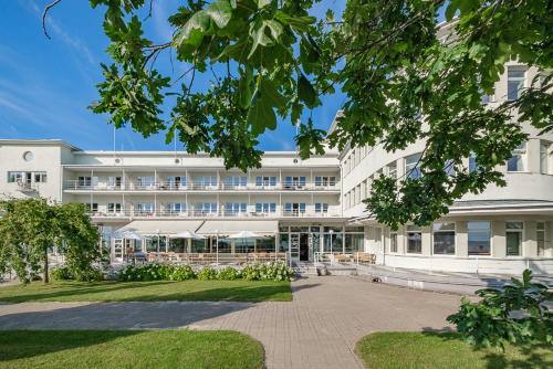 a large white building with a courtyard at Rannahotell in Pärnu