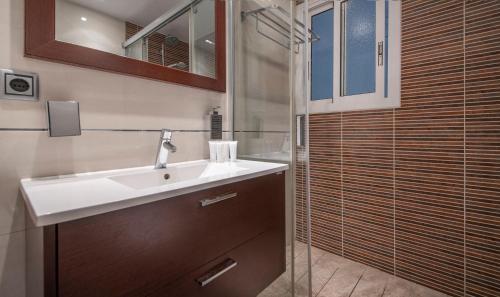 Un baño con lavabo y ducha de cristal. en R114 Apartment Ca La Laura, en Calafell