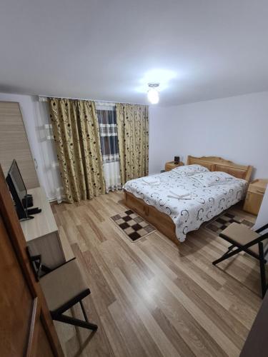 a bedroom with a bed and a wooden floor at Casa Toader in Gura Teghii