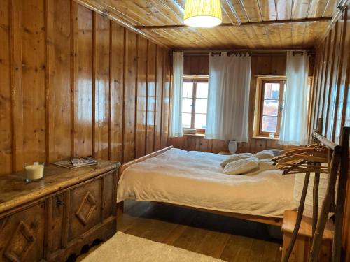 ein Schlafzimmer mit einem Bett und einer Holzwand in der Unterkunft L'ancienne Poste - Maison Napoléon in Bourg-Saint-Pierre