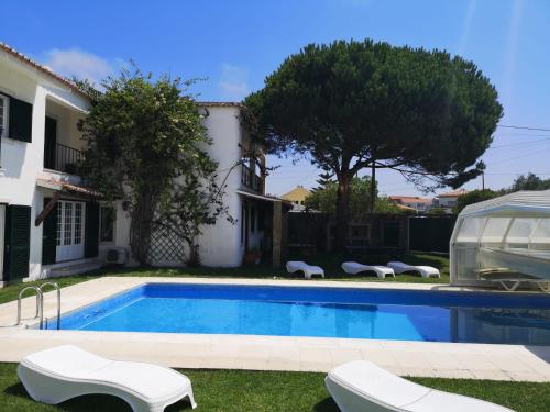 a swimming pool in front of a house at Solar das Mimosas 2 casas in Sintra