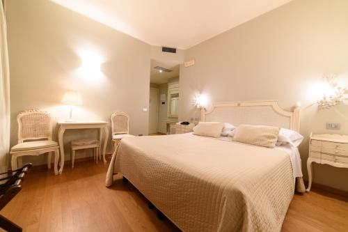 a bedroom with a bed and a table and chairs at Hotel Dei Fiori Restaurant - Meeting & Spa in Alassio