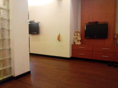 a living room with a television and a dresser at Hotel Metro Palace Bandra in Mumbai
