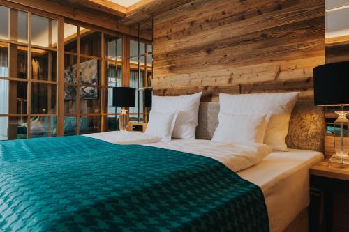 a bedroom with a large bed with wooden walls and windows at Ortner's Resort in Bad Füssing