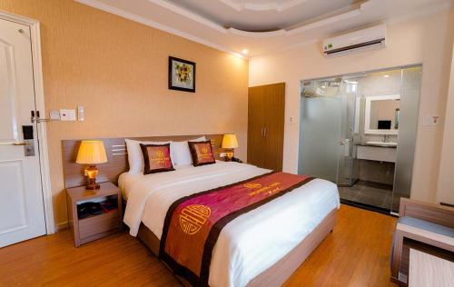 a bedroom with a large bed and a bathroom at Hoang Hai Hotel in Hai Phong