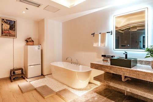 a bathroom with a large tub and a sink at King'sLandind BnB in Chongqing