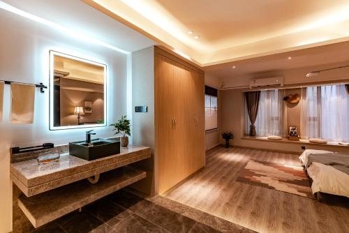 a bedroom with a sink and a bed and a mirror at King'sLandind BnB in Chongqing