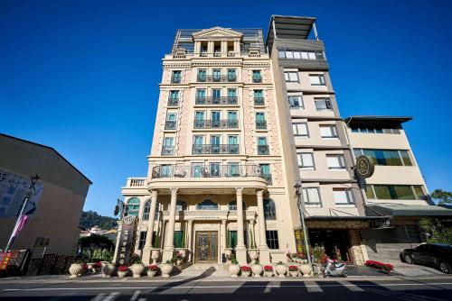 鱼池乡Sun Moon Lake Queen Castle Hotel 日月潭皇后古堡飯店的城市街道上的一栋高大的白色建筑