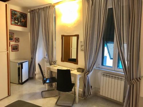 Habitación con escritorio y ventana con cortinas. en Camere Carlo en Vernazza