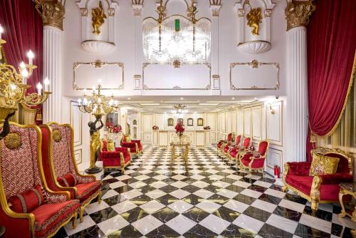 鱼池乡Sun Moon Lake Queen Castle Hotel 日月潭皇后古堡飯店的大堂设有红色椅子和 ⁇ 格地板