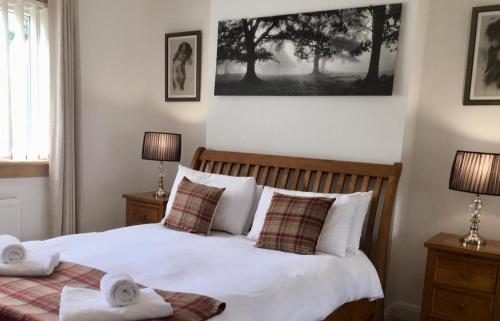 a bedroom with a bed with two towels on it at Culduthel Cottage in Inverness