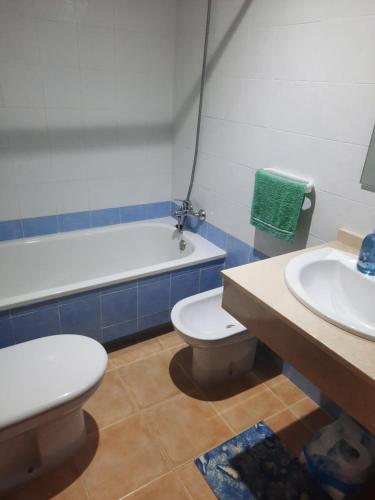 a bathroom with a toilet and a sink and a tub at Sunny Apartment in Mojácar