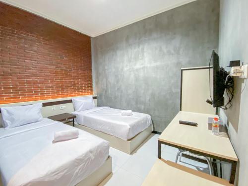 Postel nebo postele na pokoji v ubytování RedDoorz Syariah At Mitra Guest House