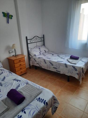 a bedroom with two beds and a dresser in it at Sunny Apartment in Mojácar