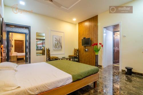 a bedroom with a bed and a tv in it at Malhar Villa -Kashid in Kashid