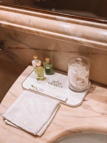 a tray with two bottles of essential oils on a sink at Relais Villabella Hotel in San Bonifacio