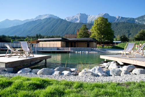 a couple of chairs sitting on a dock in the water at Gerhardhof - Zimmer Glamping Camping in Wildermieming