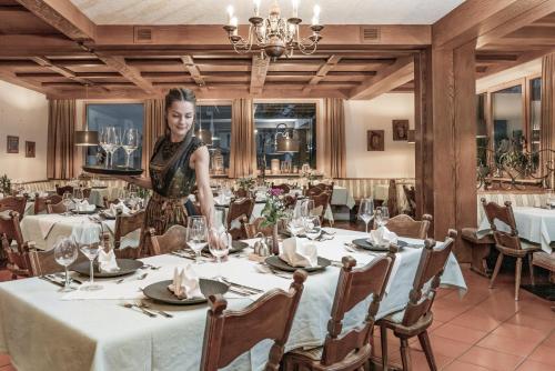 a woman standing in front of a table in a restaurant at Vera Monti in Holzgau